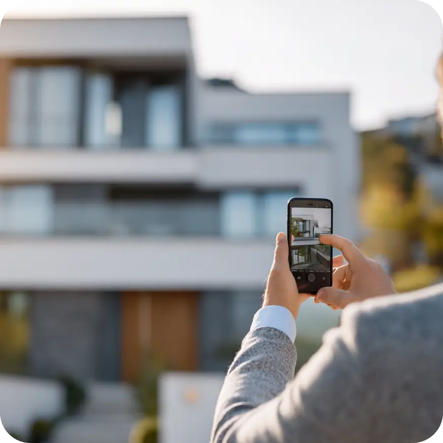 Real estate agent capturing photos of a modern home exterior